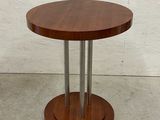 une table ronde en bois avec deux pieds en métal et un plateau en bois