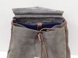 grey waxed canvas backpack with blue lining and brown leather handles