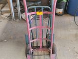 a pink hand truck that is sitting in a garage