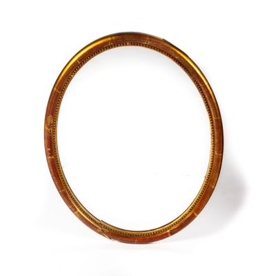 Miroir ovale en bois doré mouluré et sculpté à décor d'une f…