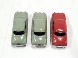 three toy cars sitting side by side on a white surface