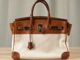 a brown and white purse sitting on top of a wooden table