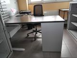 a desk with a chair and a computer on it