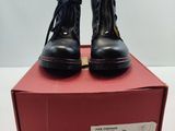 des bottines en cuir noir avec des fermetures éclair sur le dessus d'une boîte rouge