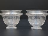 two glass vases sitting next to each other on a table
