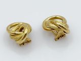 a pair of gold tone earrings with a knot design
