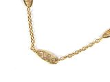 a close up of a gold necklace with a leaf design