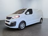 La petite camionnette blanche est garée dans une grande pièce.