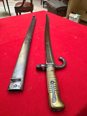 two old swords are on a red cloth on a table