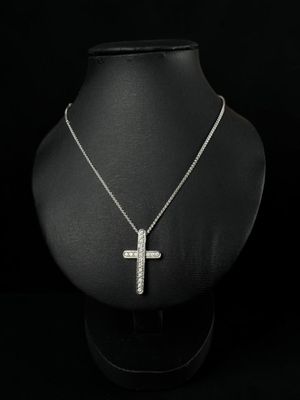 a necklace with a cross pendant on a mannequin mannequin