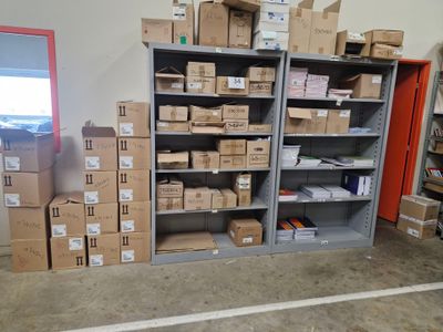 une pièce avec beaucoup de boîtes et de cartons sur les étagères