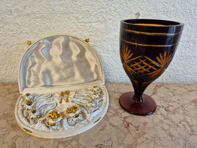un gobelet noir et doré posé à côté d'une boîte blanche