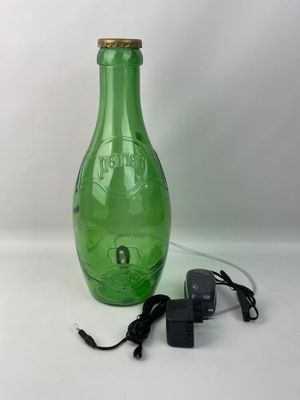 une image représentant une bouteille en verre verte à laquelle est relié un cordon d'alimentation