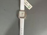a close up of a watch on a table with a tag on it