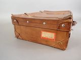 a brown suitcase sitting on top of a white table