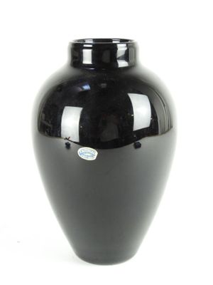 a black vase that is sitting on a white surface