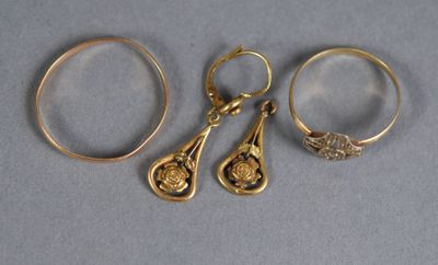 three gold rings and a pair of scissors sit on a table