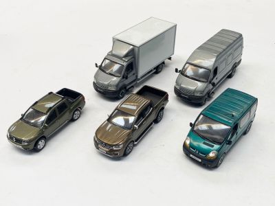 cinq petites voitures et un camion posés sur une surface blanche