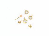 cinq paires de boucles d'oreilles en or posées sur une surface blanche
