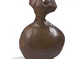 a brown vase that is sitting on a white surface