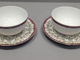 two cups and saucers are sitting on a table