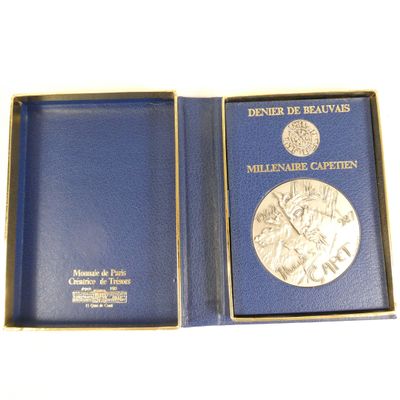 a blue box with a silver medal inside of it