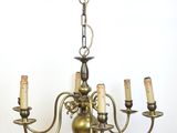 une image représentant un lustre auquel sont suspendues cinq bougies, fixé au plafond