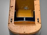 a small wooden box with a metal lid on a gray surface