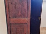 a tall wooden cabinet in the corner of a room