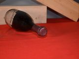 a bottle of wine sitting on a table next to a piece of wood