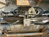 a machine that is sitting on the ground next to a bucket