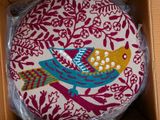 a decorative pillow in a box with a bird on it