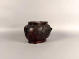 a small brown vase with a handle on a white surface