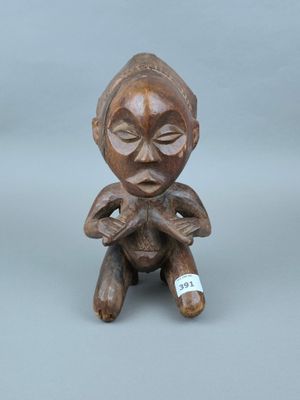 deux petites figurines en bois représentant une femme avec un bébé sur les genoux