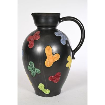 un vase noir orné de papillons colorés peints dessus