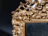 an image of a gold framed mirror with a bird on it