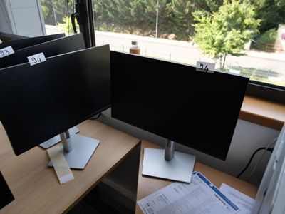 deux écrans posés sur un bureau devant une fenêtre