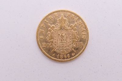 gros plan d'une pièce d'or sur une surface blanche