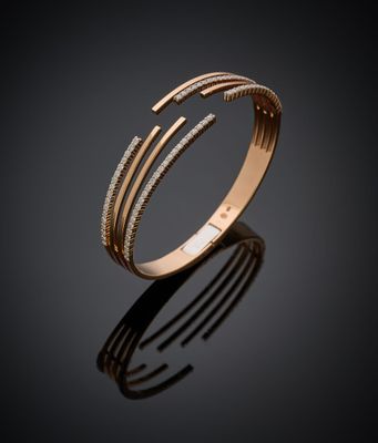 un gros plan d'un bracelet en or serti de diamants sur fond noir