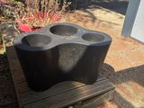un porte-gobelet en plastique noir posé sur un banc en bois