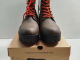 pair of brown boots with orange laces sitting on top of a cardboard box