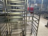 une étagère métallique sur laquelle sont posés plusieurs plateaux de nourriture