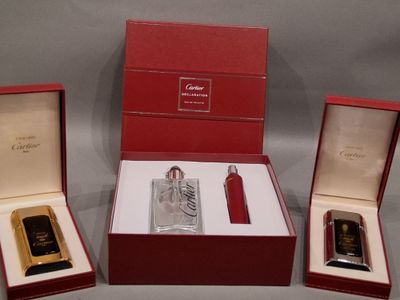 trois types de parfums différents dans une boîte rouge posée sur une surface grise