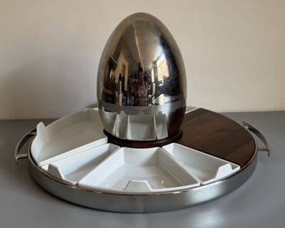 un œuf en argent posé sur un plateau en argent
