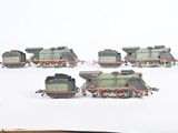 several toy trains are lined up in a row on a snowy surface