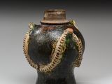 une image représentant un vase noir avec un serpent sur l'anse