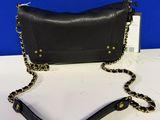 un sac à main noir avec une chaîne dorée et une bandoulière en chaîne