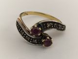 a close up of a ring with two stones on it
