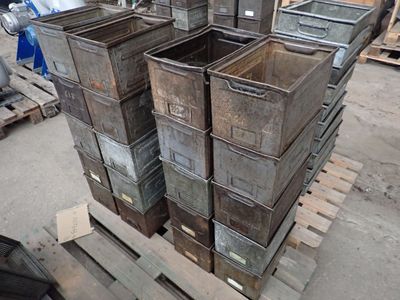 de nombreux conteneurs métalliques empilés sur des palettes dans un entrepôt