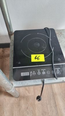 une plaque de cuisson noire sur laquelle est collé un autocollant jaune